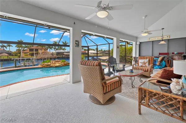 a living room with patio furniture and a floor to ceiling window