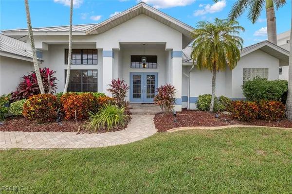 a front view of a house with a yard and potted plants