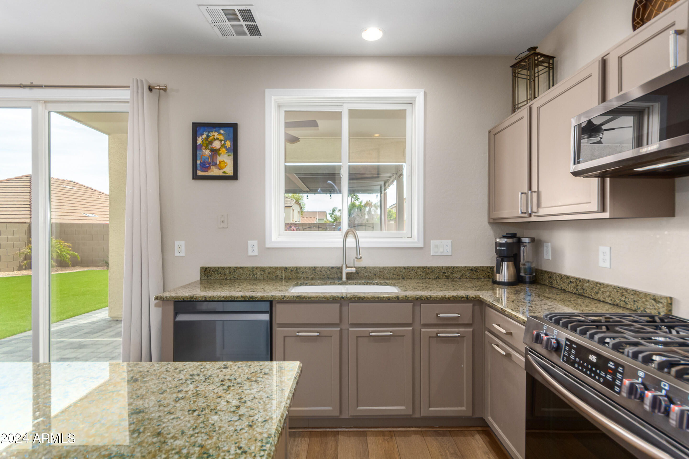 17149 West Rimrock Street Surprise, AZ 85388 - Photo 11 of 46 a kitchen with stainless steel appliances granite countertop a sink stove and refrigerator