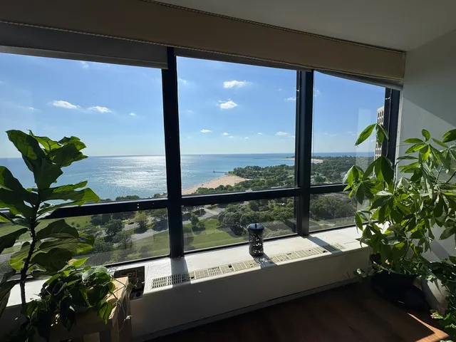 a living room with large window and a table