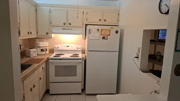 a kitchen with a refrigerator and a stove top open