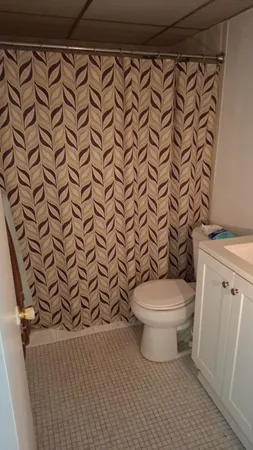 a white toilet sitting next to a white wall