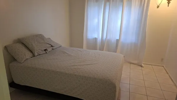 a bed sitting in a bedroom next to a window