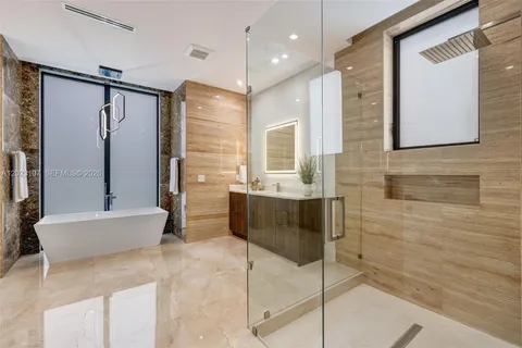 a bathroom with a large tub a sink a window and a shower