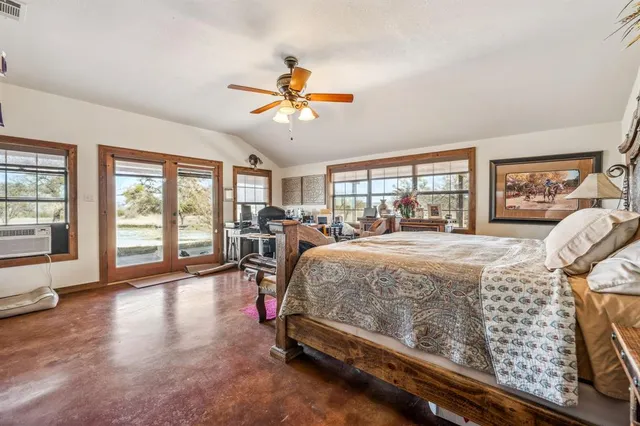 a bedroom with a bed and a large window with outer view