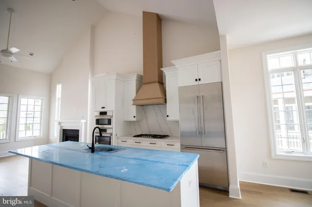 a kitchen with stainless steel appliances granite countertop a sink a stove and a refrigerator