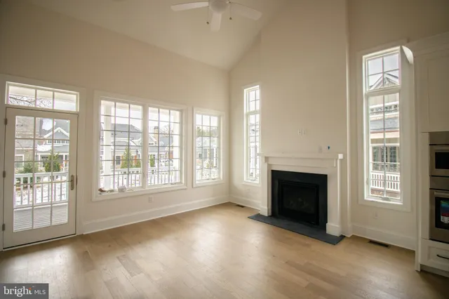 wooden floor fireplace and windows in an empty room