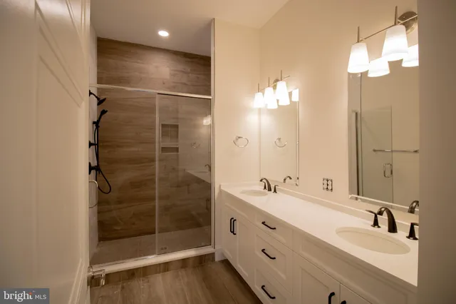 a bathroom with a double vanity sink mirror and shower