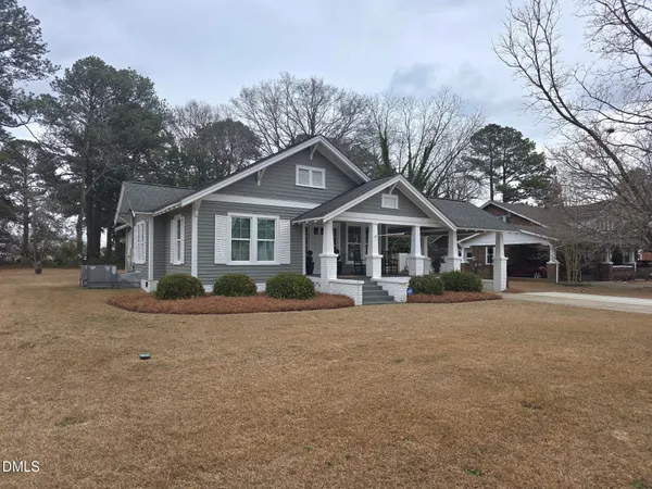 a front view of a house with yard and trees