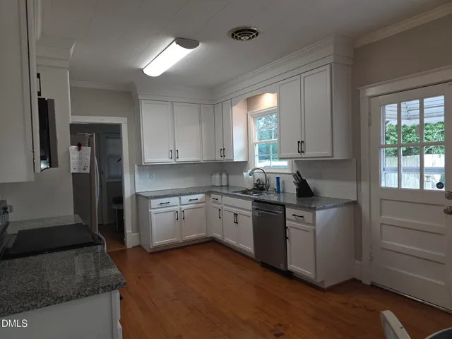 a kitchen with granite countertop white cabinets and white appliances