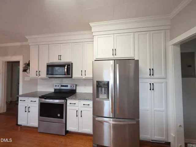 a kitchen with stainless steel appliances a refrigerator a stove a microwave and cabinets