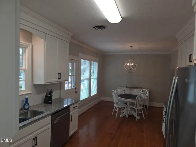 a kitchen with stainless steel appliances granite countertop a sink refrigerator and cabinets