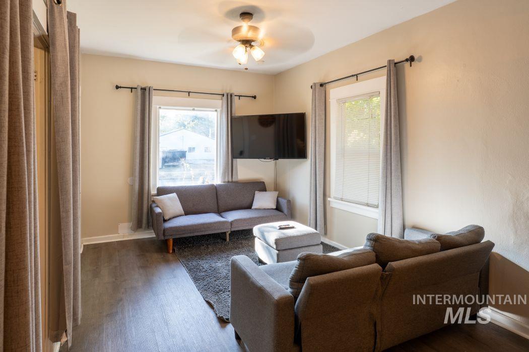 Living room featuring wood finished floors, plenty of natural light, and a ceiling fan