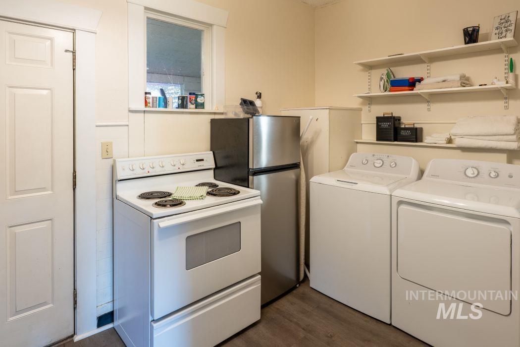 112 South Asbury Street Moscow, ID 83843 - Photo 13 of 26 Kitchen featuring white electric range, dark wood-type flooring, open shelves, freestanding refrigerator, and independent washer and dryer