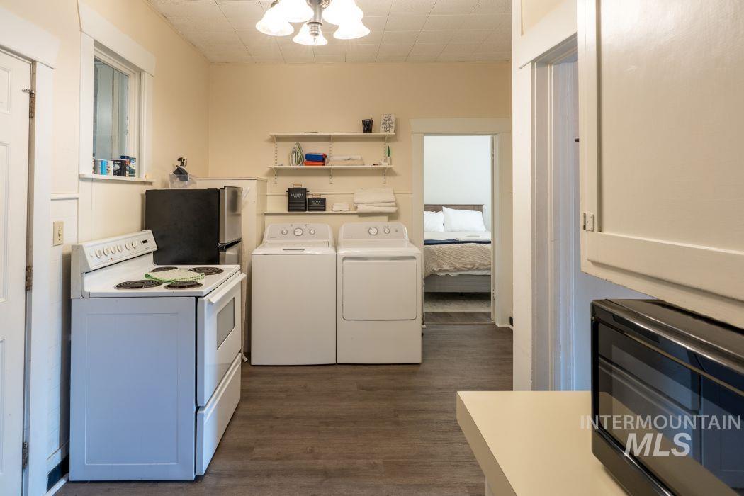 112 South Asbury Street Moscow, ID 83843 - Photo 14 of 26 Kitchen featuring white electric stove, open shelves, dark wood-style flooring, light countertops, and separate washer and dryer