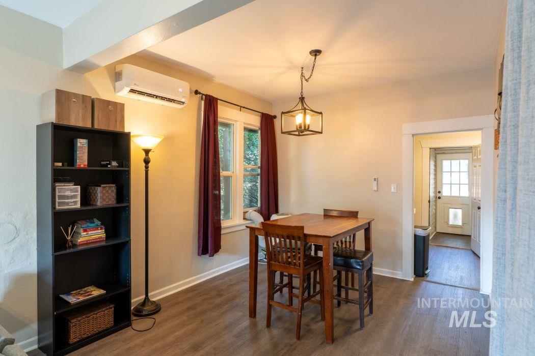 112 South Asbury Street Moscow, ID 83843 - Photo 6 of 26 Dining area with dark wood-type flooring, a wall unit AC, and a chandelier