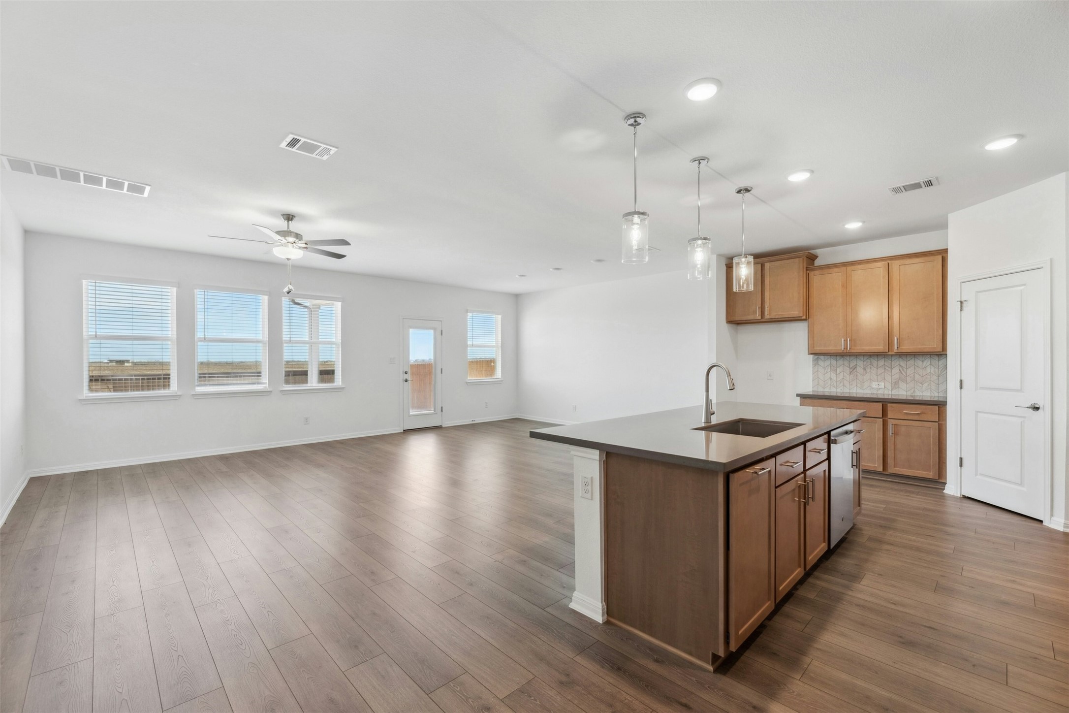 2001 Wynn Road Hutto, TX 78634 - Photo 4 of 39 An open-concept living area boasts continuous flooring and a modern kitchen island, creating a fluid and inviting space.
