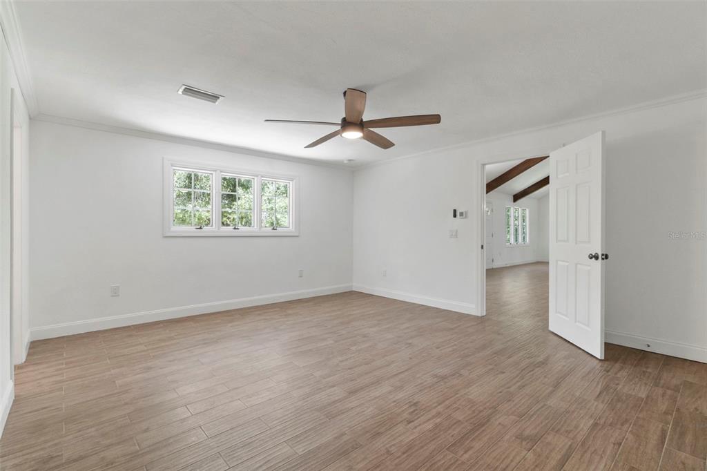 1183 Northwest Girl Scout Road Arcadia, FL 34266 - Photo 12 of 43 an empty room with wooden floor ceiling fan and windows
