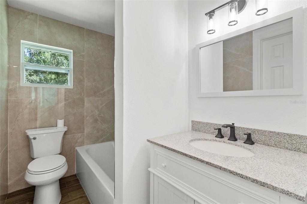 1183 Northwest Girl Scout Road Arcadia, FL 34266 - Photo 18 of 43 a bathroom with a granite countertop toilet sink and mirror