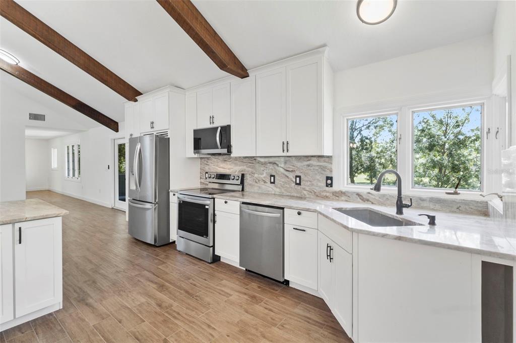 1183 Northwest Girl Scout Road Arcadia, FL 34266 - Photo 4 of 43 a kitchen with appliances cabinets a sink and a large window