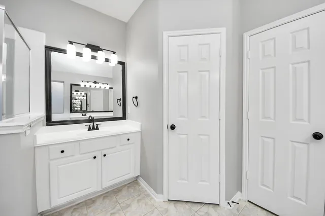 a bathroom with a double vanity sink and mirror