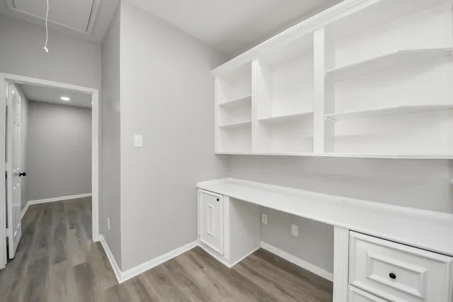 a room with a wooden floor and cabinets