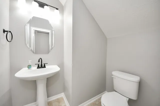 a bathroom with a toilet sink and mirror