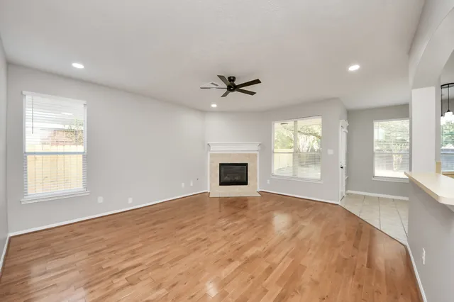 a view of an empty room with a window and a kitchen