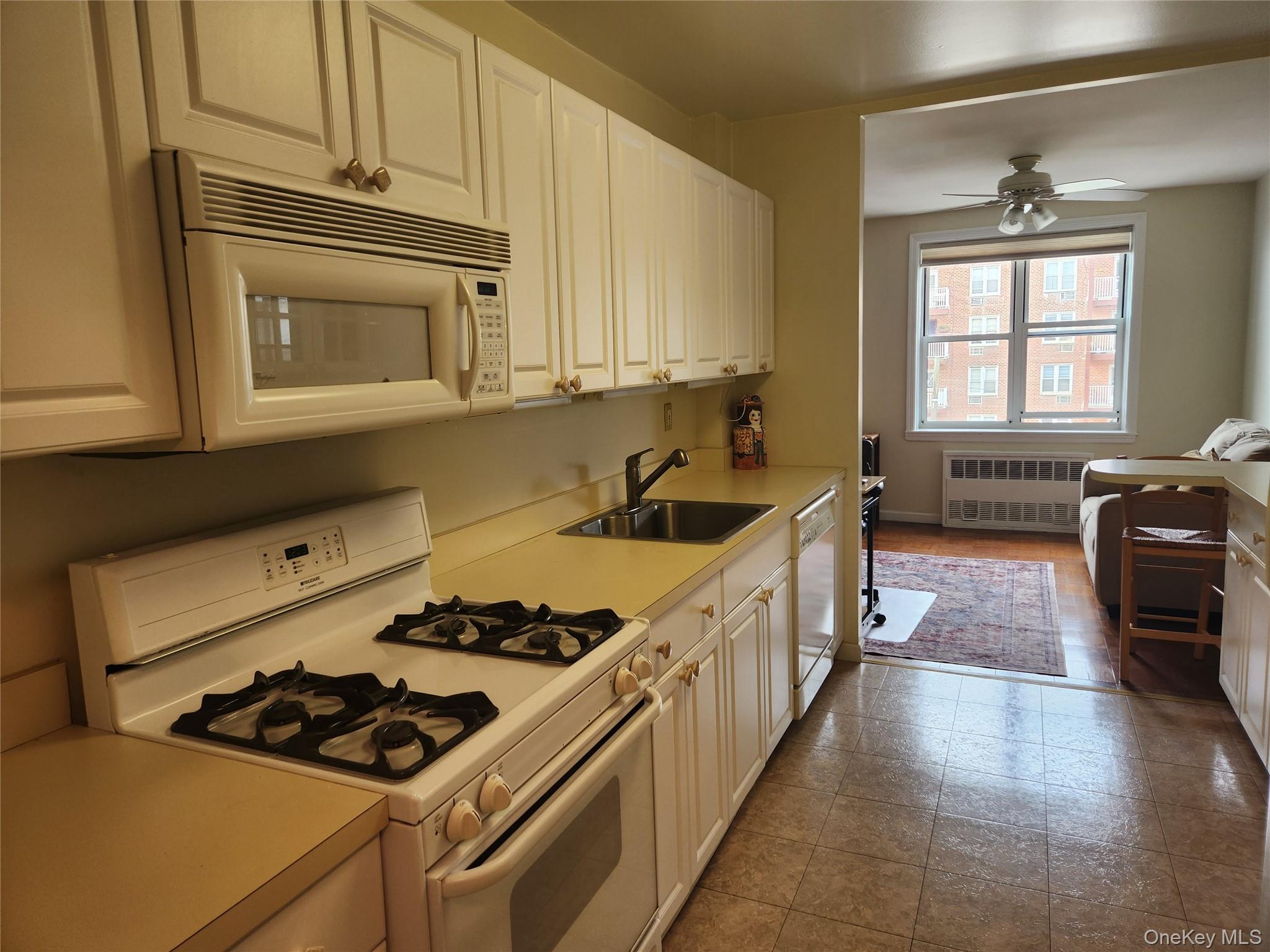 700 Shore Road, Unit 4K Long Beach, NY 11561 - Photo 11 of 32 Kitchen with white appliances, light counter tops, white cabinets..