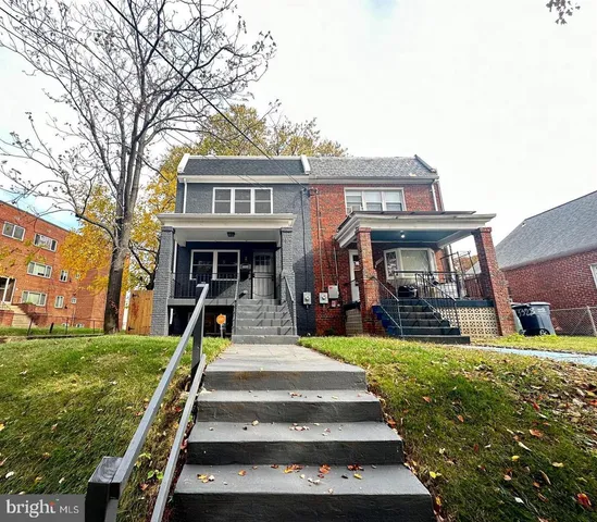 a view of an entryway with wooden floor and a kitchen