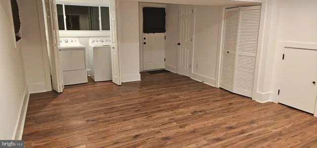 a view of a hallway with wooden floor and white doors