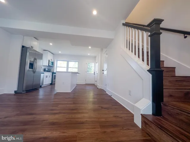 a view of an entryway with wooden floor and a kitchen