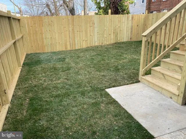 a view of backyard with wooden fence