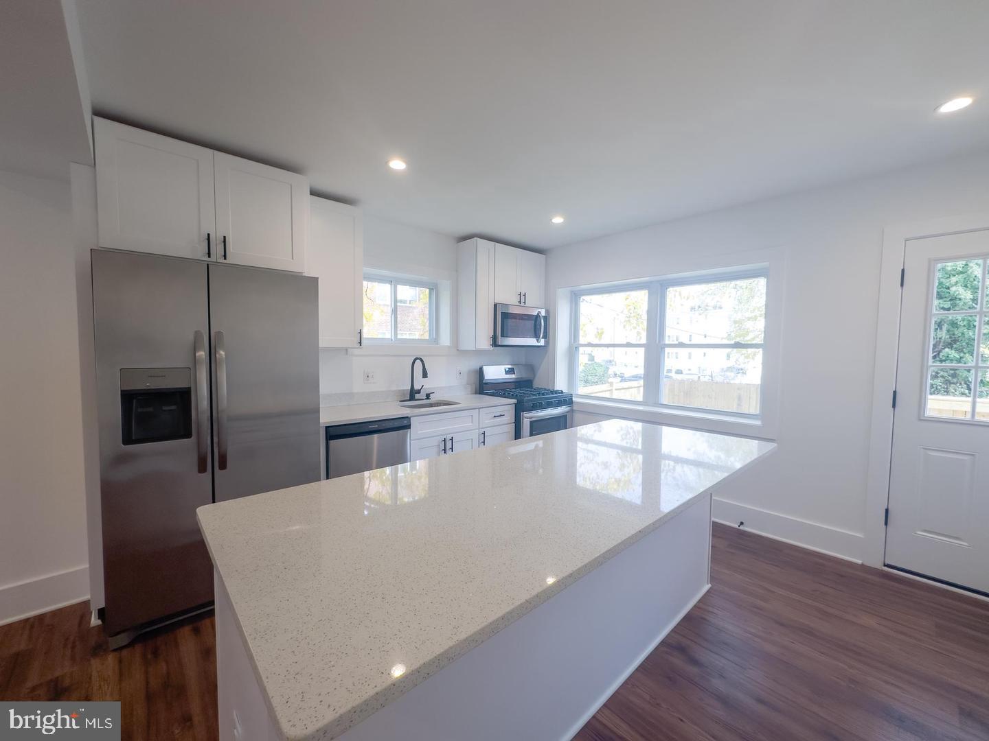 3326 12th Street Southeast Washington, DC 20032 - Photo 4 of 19 a large kitchen with kitchen island a large window a sink and stainless steel appliances