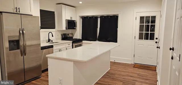 a kitchen with stainless steel appliances a refrigerator and a stove