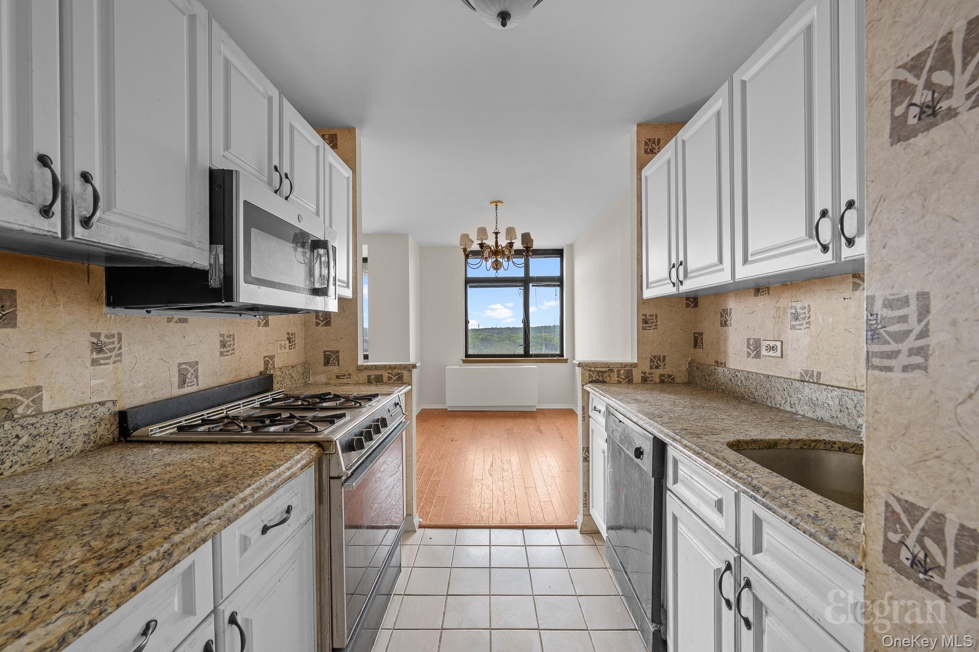 11201 Queens Boulevard, Unit 16F Queens, NY 11375 - Photo 3 of 24 a kitchen with granite countertop a sink a stove and cabinets