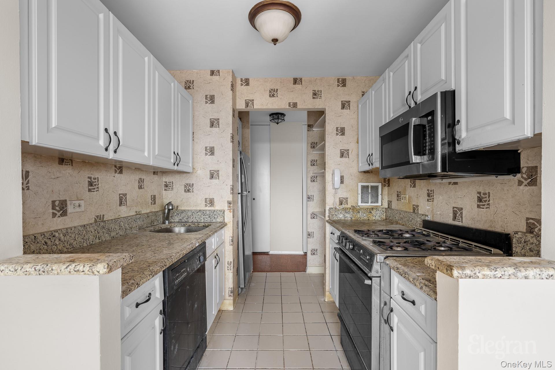 11201 Queens Boulevard, Unit 16F Queens, NY 11375 - Photo 4 of 24 a kitchen with stainless steel appliances granite countertop a stove and a white cabinets