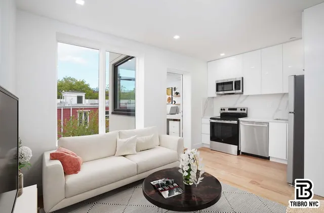 a living room with furniture and a kitchen