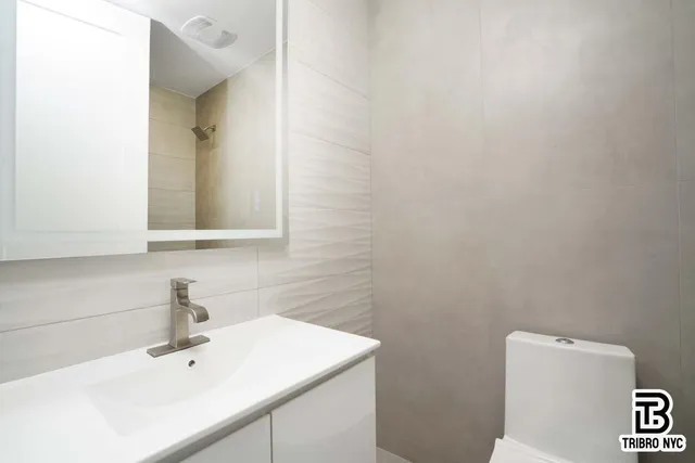 a bathroom with a toilet sink and mirror