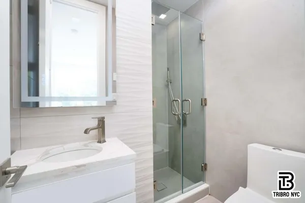 a bathroom with a sink a toilet and shower