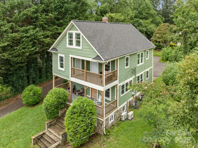 a aerial view of a house next to a big yard and large trees
