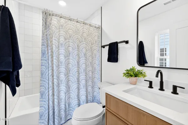 a bathroom with a sink a toilet and shower curtain