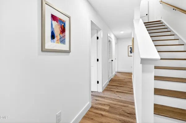a view of a hallway with wooden floor and staircase