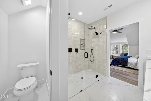 a bathroom with a shower a toilet and a sink
