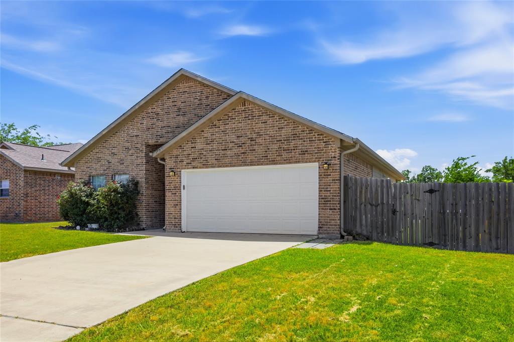 1502 Reed Street Greenville, TX 75401 - Photo 2 of 26 Brick exterior with a white garage door