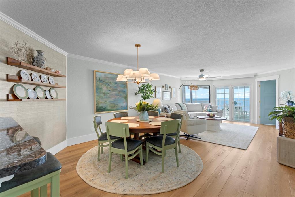 16332 Gulf Boulevard, Unit 3B Redington Beach, FL 33708 - Photo 25 of 91 a dining room with furniture a chandelier and wooden floor