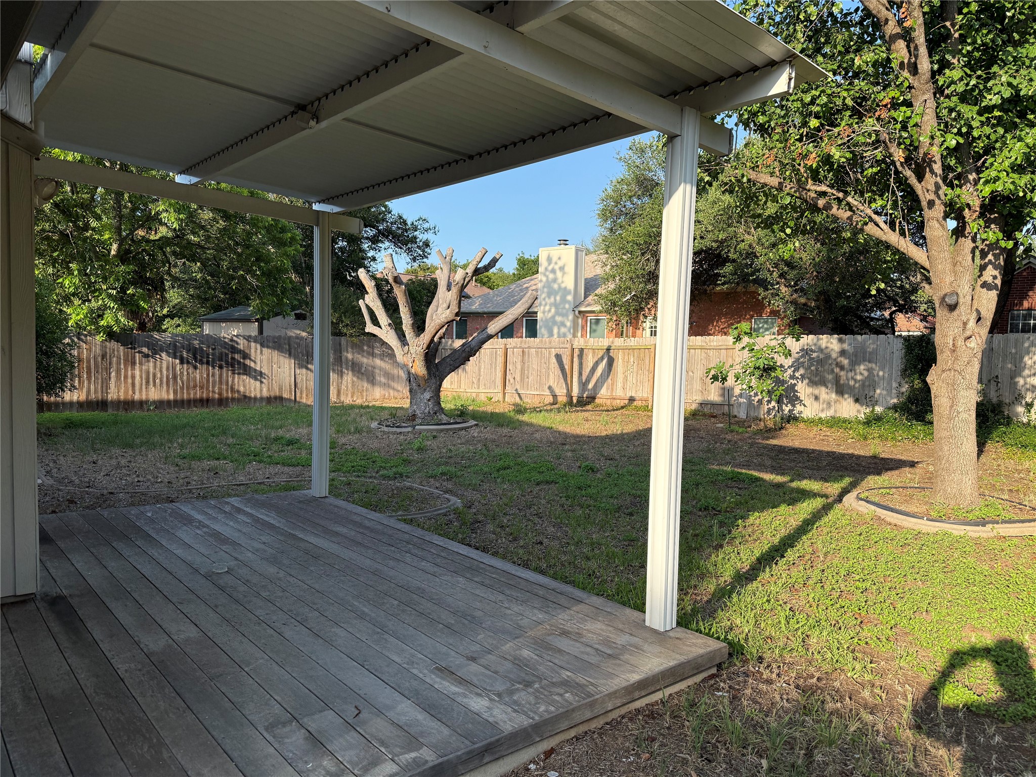 1316 Mesquite Road Cedar Park, TX 78613 - Photo 24 of 24 A spacious backyard with mature trees and a covered deck, perfect for outdoor enjoyment.