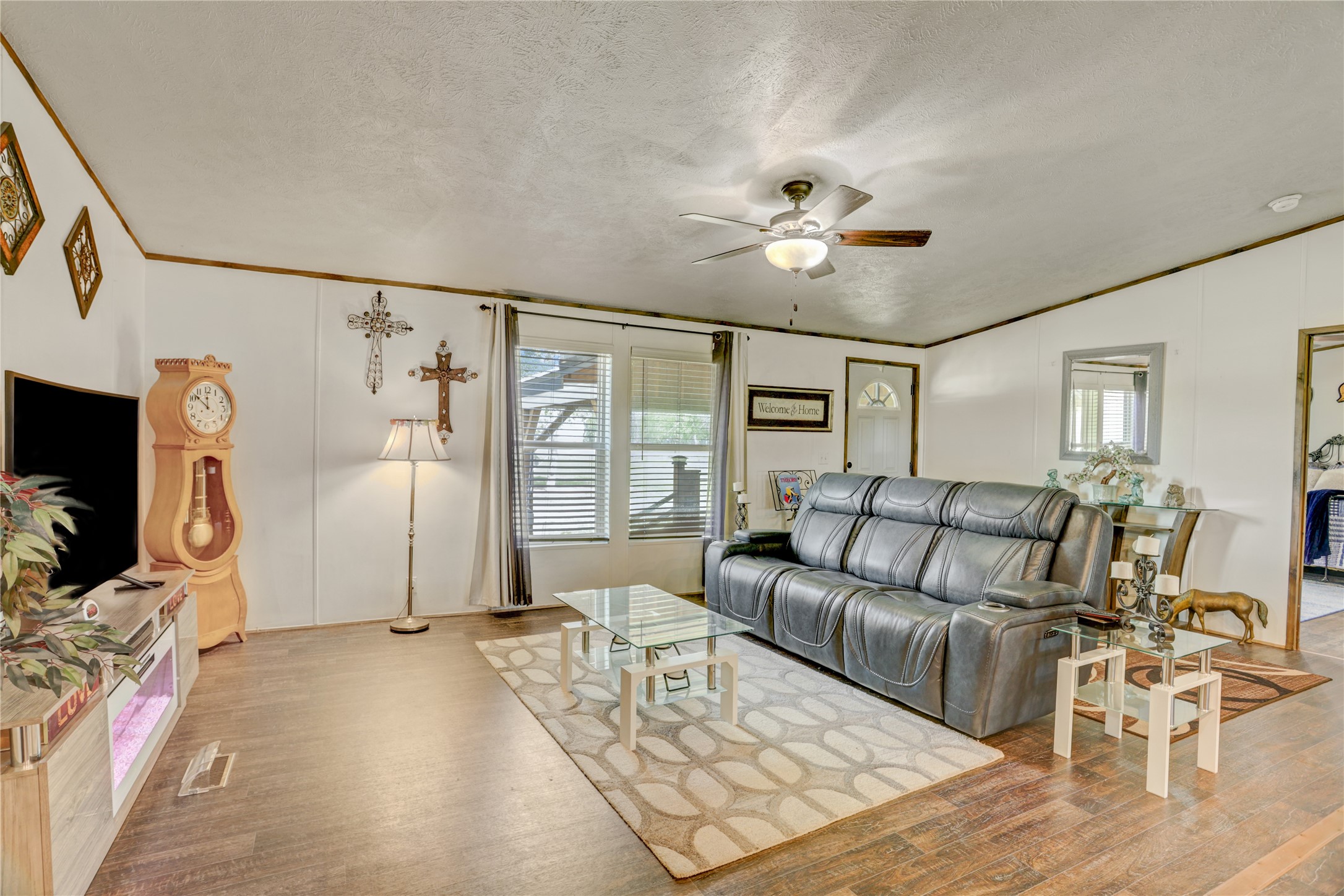 2811 Pisces Street Rosenberg, TX 77469 - Photo 15 of 34 Bright living room with wood flooring, featuring a ceiling fan and large windows.