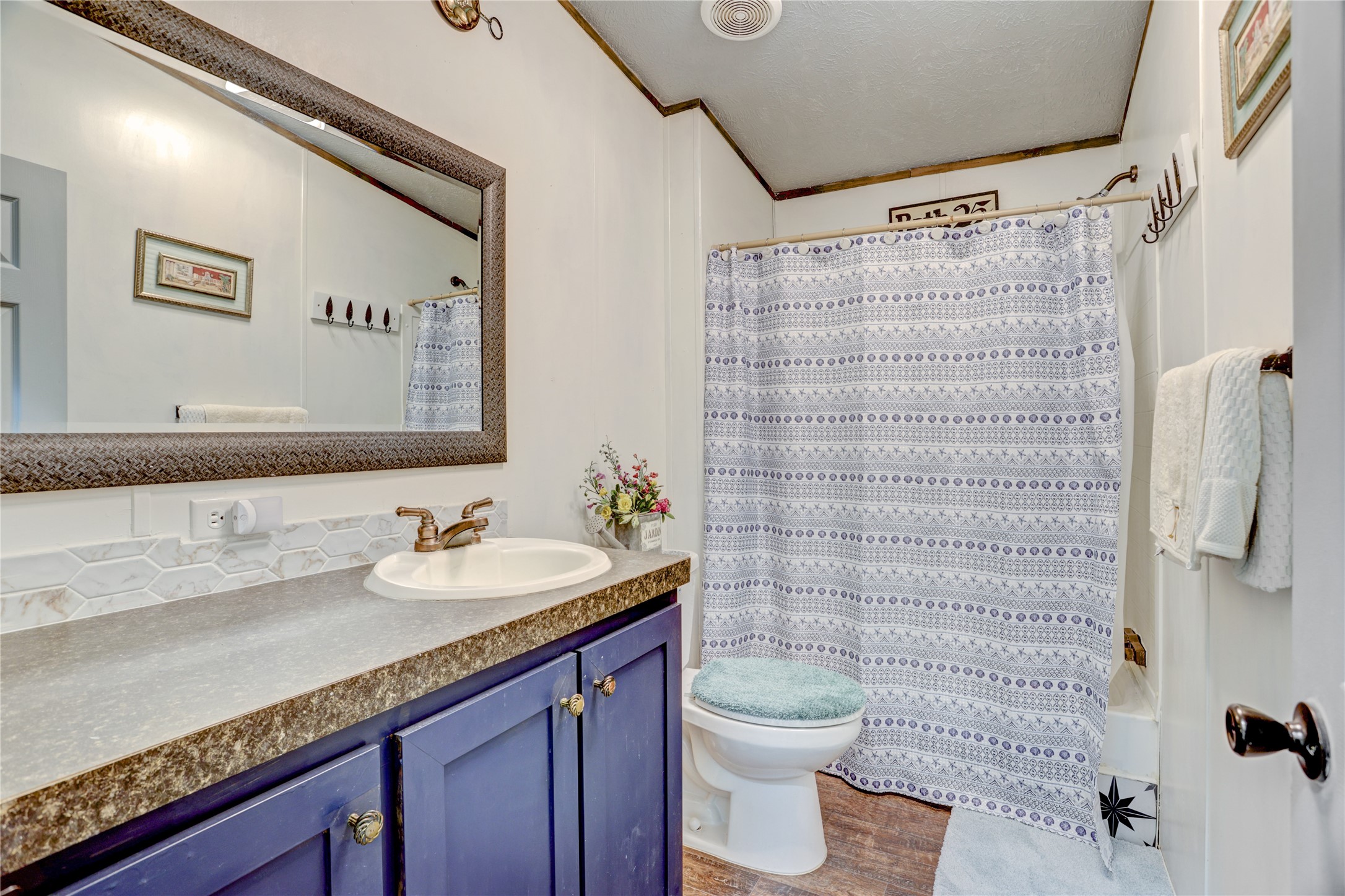 2811 Pisces Street Rosenberg, TX 77469 - Photo 22 of 34 Modern bathroom with blue cabinetry, spacious vanity, large mirror, and a shower-tub combo.