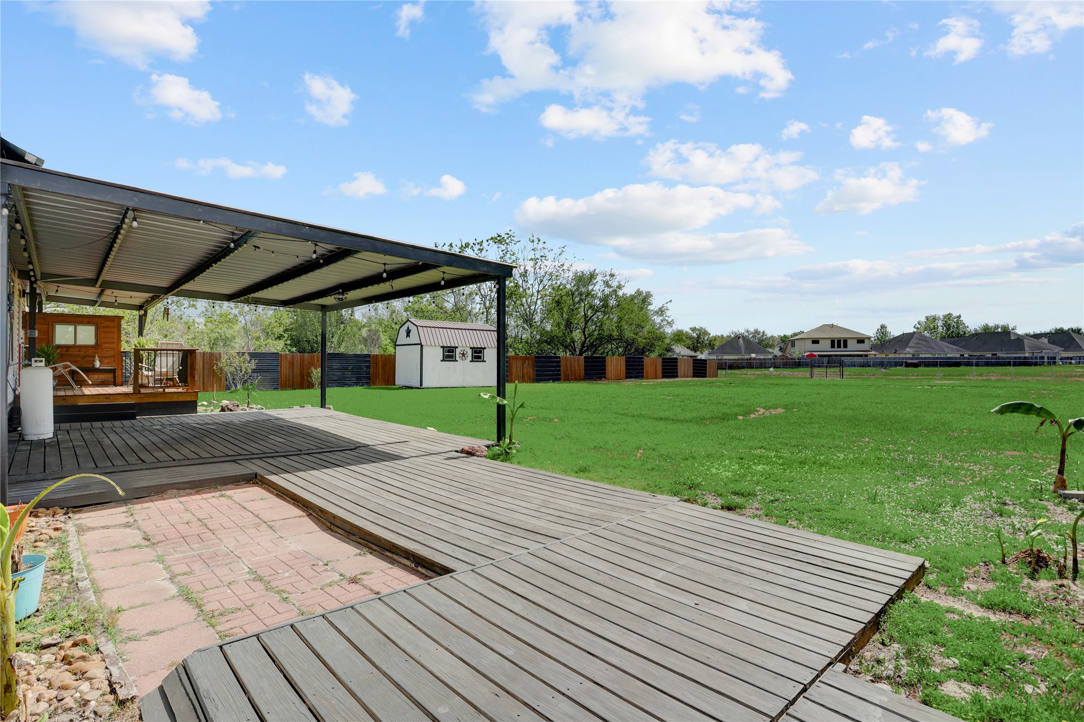 2811 Pisces Street Rosenberg, TX 77469 - Photo 25 of 34 Well-maintained lawn with a small shed and fenced privacy.